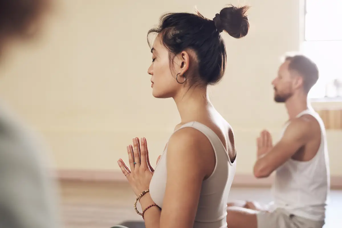 Shot of a group of young people meditating and practicing yoga together inside a yoga studio