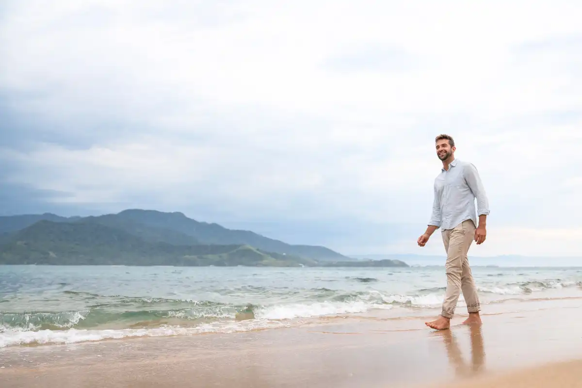 a man walking on the shore near a Luxury Southern California Drug Rehab