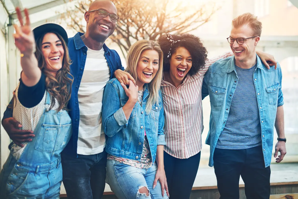 carefree laughing men and women standing and embracing having fun together