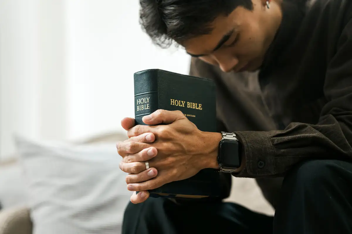 man praying holding a bible in Faith-Based Luxury Drug and Alcohol Rehab