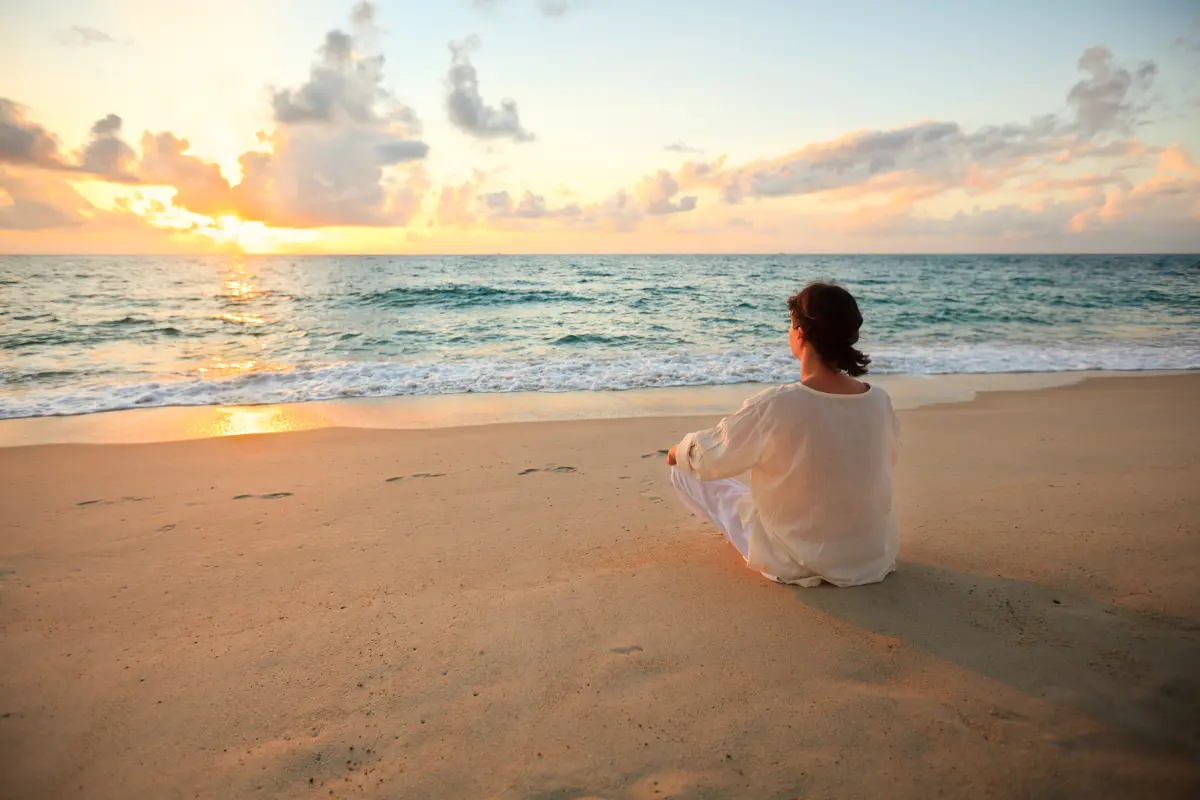 woman sitting on the beach sand near Luxury Southern California Drug and Alcohol Detox